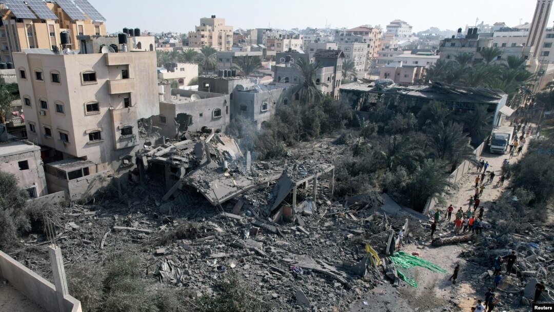 Palestinians gather at the site of an Israeli strike on a house, in Deir Al-Balah