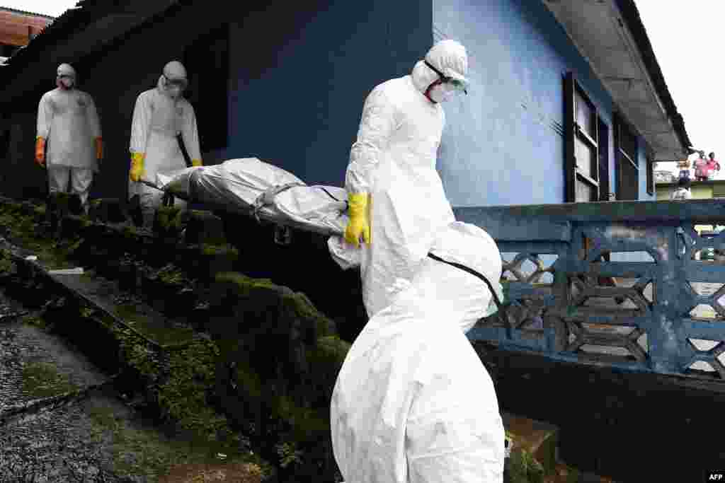 Medical staff members of the Croix Rouge NGO carry on a stretcher the corpse of a victim of Ebola, after collecting it from a house in Monrovia, Sept. 29, 2014.