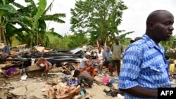 Des habitants d'un bidonville d'Abidjan au milieu des gravats de leurs maisons détruites par pluies diluviennes, à Abidjan, 26 mai 2017.