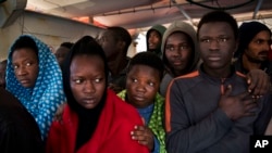 Les migrants à bord du bateau de sauvetage Golfo Azurro attendent d'être transférés aux autorités italiennes dans le port de Trapani, sur l'île italienne de Sicile, 8 avril 2017.