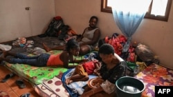 Migrantes haitianos descansan en una iglesia evangélica mientras esperan que la oficina de migraciones les dé un resguardo para continuar su camino en una caravana rumbo a Estados Unidos, en el municipio de Trojes, Honduras, el 21 de abril de 2021.