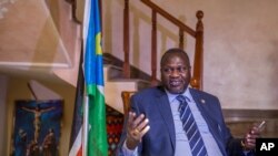 FILE - South Sudan rebel leader Riek Machar talks to reporters at his private residence in Ethiopian capital, Addis Ababa, Feb. 13, 2016. He says he is ready to return to Juba in March to take up his position as first vice president.