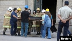 Para petugas penyelamat dan staf museum menyelamatkan sebuah lukisan dari Museum Nasional Brazil di Rio de Janeiro, Brazil, 3 September, 2018. 