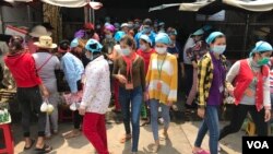 Garment workers leave the Propitious (Cambodia) Garment Ltd. factory for a lunch break in Kandal province, Cambodia, March 20, 2020. (Kann Vicheika/VOA Khmer)