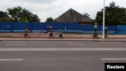 Une femme congolaise court près de la RTNC, Kinshasa, 30 décembre 2013.