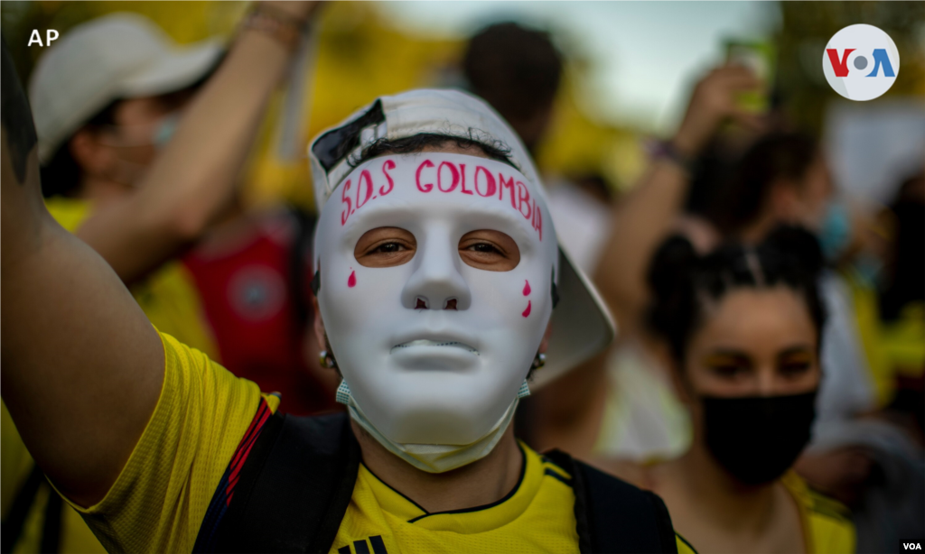 Un hombre con una máscara que dice: "SOS Colombia" participa durante una protesta contra la violencia en Colombia. Madrid, España, 6 de mayo de 2021.