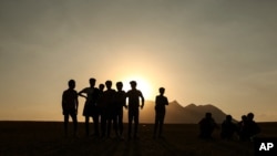 In this Aug. 17, 2021, file photo, young men who say they deserted the Afghan military and fled to Turkey through Iran stand in the countryside in Tatvan, in Bitlis Province in eastern Turkey.