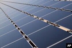 FILE- This April 20, 2011, file photo shows some of the 30,000 solar panels that make up the Public Service Company of New Mexico's new 2-megawatt photovoltaic array in Albuquerque, New Mexico.