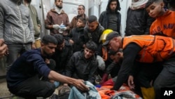Palestinians mourn over the bodies of civil defense workers, victims of an Israeli army strike in the Nuseirat camp, at the Al-Aqsa Martyrs hospital in Deir al-Balah, central Gaza Strip, Dec.16, 2024.