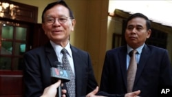 Cambodia's opposition leader Kem Sokha, left, talks to the media at his home before leaving for the court hearing in Phnom Penh, Thursday, Jan. 16, 2020.
