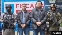 Los hermanos Andres Felipe y Ramen Emilio Perez Hoyos son fotografiados, esposados con escolta policial, tras ser arrestados en Río Negro, Colombia, el 15 de enero de 2023.