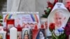 Velas, flores y un retrato del papa Francisco se colocan en la estatua de Juan Pablo II afuera del hospital Gemelli, donde está hospitalizado el Papa Francisco, en Roma, el 24 de febrero de 2025.