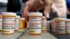 Family and friends who have lost loved ones to OxyContin and opioid overdoses leave pill bottles in protest outside the headquarters of Purdue Pharma, which is owned by the Sackler family, in Stamford, Conn., Aug. 17, 2018.
