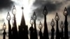 FILE - Russian servicemen (not pictured) hold flags with pikes topped with hammers and sickles, symbolic of Soviet times, with a Kremlin tower seen in the background, during a military parade rehearsal in Red Square in Moscow, Russia, Nov. 5, 2012.