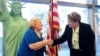 Un nuevo ciudadano estadounidense Tamam Shanazarian, a la izquierda, le da la mano a Nancy Alby, directora de campo de USCIS Los Ángeles, durante una ceremonia de naturalización antes del Día Mundial del Refugiado realizada por los Servicios de Ciudadanía
