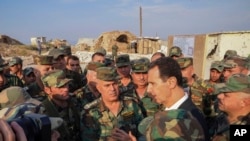 Presiden Suriah Bashar Assad, kanan tengah, berbicara dengan pasukan Suriah selama kunjungannya ke kota strategis Habeet, Idlib, Suriah. (Foto: AP)