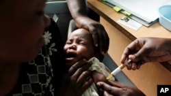 Une mère tient dans ses bras son bébé quo reçoit un nouveau vaccin contre le paludisme dans le cadre d'un essai mené au centre de recherche du projet Walter Reed à Kombewa, dans l'ouest du Kenya, le 30 octobre 2009. (Photo AP/Karel Prinsloo, dossier)