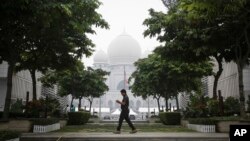 FILE - A Malaysian man walks past Palace of Justice shrouded in haze in Putrajaya, Malaysia, Sept. 11, 2015. 