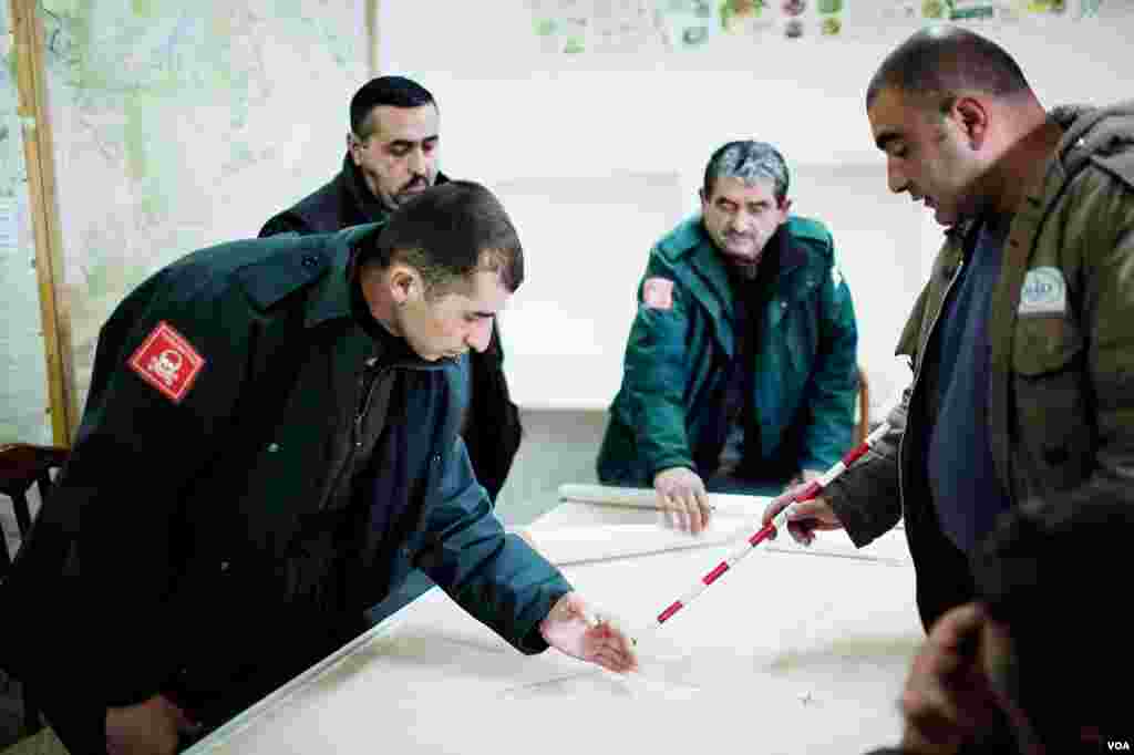 Halo Trust workers plot the locations of unexploded ordinance -- still deadly after 20 years. (U. Filimonova/VOA)