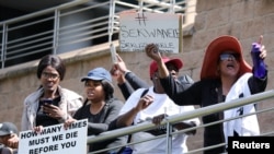 Mujeres sostienen pancartas mientras protestan contra la violencia de género, frente a la Bolsa de Valores de Johannesburgo en Sandton, Johannesburgo, Sudáfrica. [Foto de archivo]