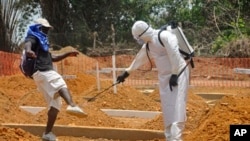 Seorang petugas kesehatan menyemprot seorang pria dengan disinfektan di untuk mencegah penularan Ebola di Monrovia, Liberia (11/3). (AP/Abbas Dulleh)