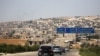 FILE - A journalists' convoy is seen at the entrance of Khan Sheikhoun, Idlib, Syria, Aug. 24, 2019.