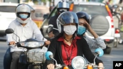 FILE - Cambodians wear masks to avoid the contact of coronavirus in Phnom Penh, Cambodia, Tuesday, Jan. 28, 2020. 