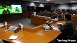 한민구 한국 국방부 장관(오른쪽)이 5일 서울 국방부 청사에서 열린 '위기상황 평가 및 대책회의'에서 북한 장거리 미사일 발사에 대비해 임무 수행 중인 해군 이지스함 서애류성룡함의 함장과 화상 통화를 통해 작전 상황을 보고받고 있다.