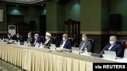 FILE - Senior officials wear face masks amid fears of coronavirus disease (COVID-19) as they attend a meeting of the Iranian government task force on the coronavirus, in Tehran, Iran, March 21, 2020. 