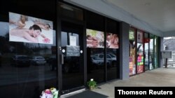 Flores colocadas frente al local de masajes donde murieron varias personas después de un tiroteo mortal en Acworth, Georgia. 