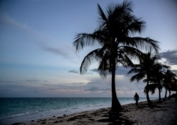 A woman walks along a beach before the arrival of Hurricane Dorian in Freeport, Grand Bahama, Bahamas, Aug. 31, 2019.