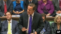 Britain's Prime Minister David Cameron, flanked by Deputy Prime Minister Nick Clegg (L) and Home Secretary Theresa May (R) speaks about phone hacking to parliament in a still image taken from video in London July 20, 2011