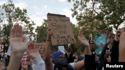 Demonstrators raise their arms during a protest against the death of African-American man George Floyd under Minneapolis police custody, in Oakland, California, U.S. May 29, 2020. REUTERS/Stephen Lam