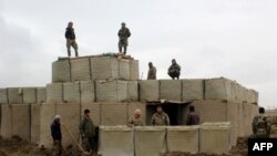 Pasukan keamanan Afghanistan berjaga di pos terdepan Tentara Nasional Afghanistan (ANA) setelah serangan oleh militan Taliban, di Provinsi Kunduz, 4 Maret 2020. (Foto: STR / AFP)