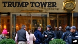FILE - A heavily-armed New York City police officer stands guard outside the Fifth Avenue, public entrance to Trump Tower, Nov. 15, 2016.