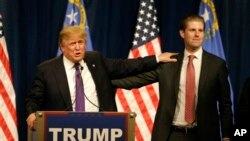 Republican presidential candidate Donald Trump, left, puts his hand on the shoulder of his son, Eric, while speaking after his caucus victory in Nevada, Feb. 23, 2016 in Las Vegas. (AP Photo/Jae C. Hong)