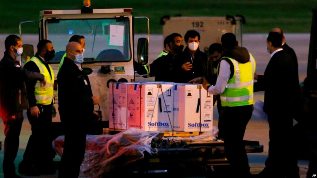 Workers stand next to boxes of the first shipment of the Pfizer-BioNTech vaccine for COVID-19 after it arrived at the Rafik Hariri International Airport in Beirut, Lebanon, Feb. 13, 2021. 