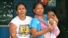 Santi with her four-month-old son and neighbor. The 26-year-old mother says she cannot afford birth registration for her children, Jakarta, Indonesia, March 2, 2013. (K. Lamb/VOA)