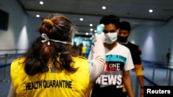 Health Quarantine officer checks people with a thermal scanner after Indonesia confirmed its first cases of coronavirus disease (COVID-19), in Soekarno Hatta International Airport, in Tangerang near Jakarta, Indonesia, March 6, 2020.