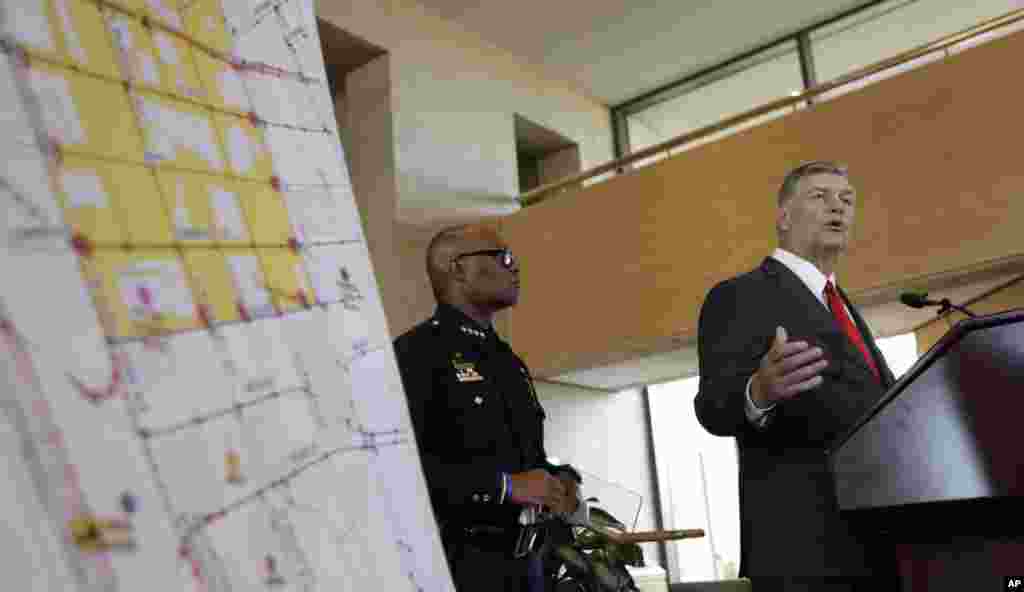 Dallas police chief David Brown, left, and Dallas mayor Mike Rawlings, right, talk with the media during a news conference, July 8, 2016, in Dallas.