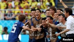 Le Japonais Yuya Osako fête son but avec son équipe et son entraîneur, lors du Mondial 2018, le 19 juin 2018.