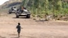 Young boy walks toward FARDC government forces tanks near the front line in Kanyaruchinya, 15 km from Goma, DRC, July 24, 2013.