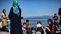 FILE - Migrants from Afghanistan arrive after crossing the Aegean Sea from Turkey with a dinghy on the Greek Mediterranean island of Lesbos on Aug. 6, 2018.
