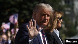 U.S. President Donald Trump waves to reporters as he departs with first lady Melania Trump for campaign travel to participate in his first presidential debate with Democratic presidential nominee Joe Biden in Cleveland, Ohio.