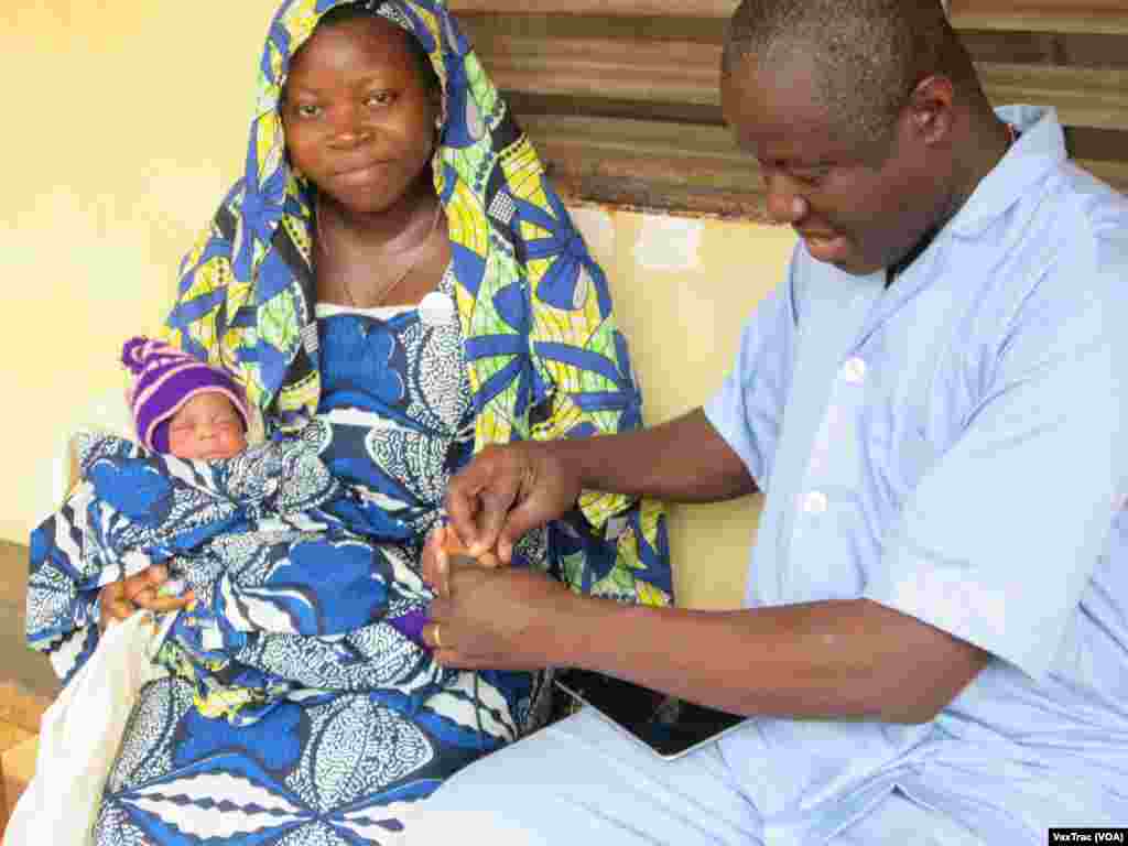 A portable scanner is used to scan a mother’s thumb which can also help track her baby. (VaxTrac)