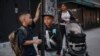 ARCHIVO - Kimberly Carchipulla, a la derecha, y su hijo Damien, de 5 años, en el centro, esperan el autobús camino a la escuela el jueves 7 de septiembre de 2023, en Nueva York.