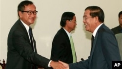 Cambodian Prime Minister Hun Sen shakes hands with opposition leader Sam Rainsy before a meeting at the National Assembly.