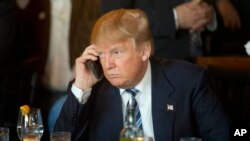 FILE - Then-Republican presidential candidate Donald Trump uses his mobile phone during a lunch stop in North Charleston, S.C., Feb. 18, 2016. The president took to Twitter July 29, 2017, to criticize Republican senators.