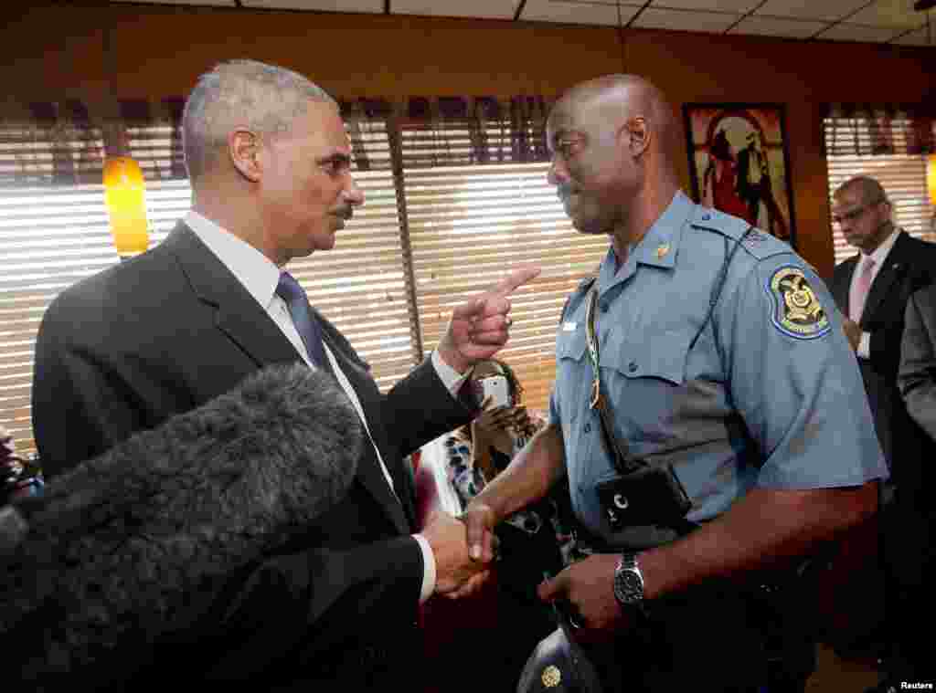 Jaksa Agung AS Eric Holder berbicara dengan Kapten Ron Johnson dari Patroli Jalan Layang Missouri di Restauran Drake's Place di Ferguson, Missouri (20/8). (Reuters/Pablo Martinez Monsivais)