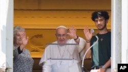 El papa Francisco, acompañado por una abuela y su nieto en el Día de los Abuelos, durante el rezo del Ángelus en la Plaza de San Pedro del Vaticano el 23 de julio de 2023.